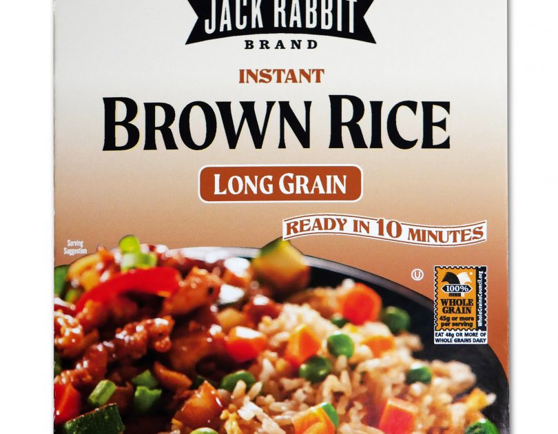 Brown package of Jack Rabbit Brand Instant Brown Rice. The box reads, "Gluten Free - Non-GMO - Precooked, Jack Rabbit Brand Instant Brown Rice, long grain, ready in 10 minutes." The box has an image of a brown rice dish with meat and vegetables.
