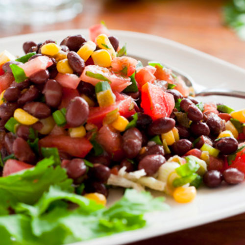 bb_salsa Red beans, corn, tomato, and onion mixed on a white plate with cilantro garnish.